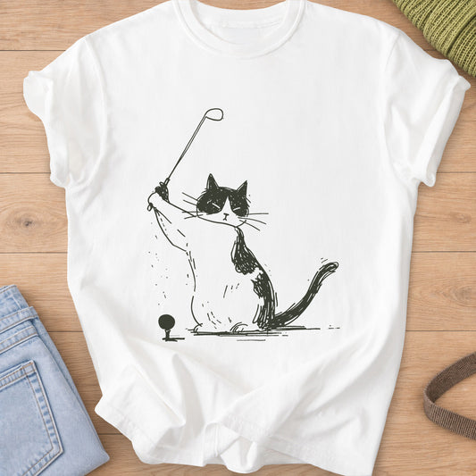 Tuxedo cat lifting a golf club into a backswing next to a ball on a tee, dark charcoal ink on a White T-Shirt