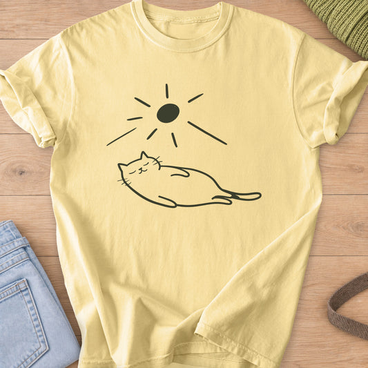 Chubby cat sleeping stretched out under a sun with long rays, dark charcoal ink on a Butter T-Shirt
