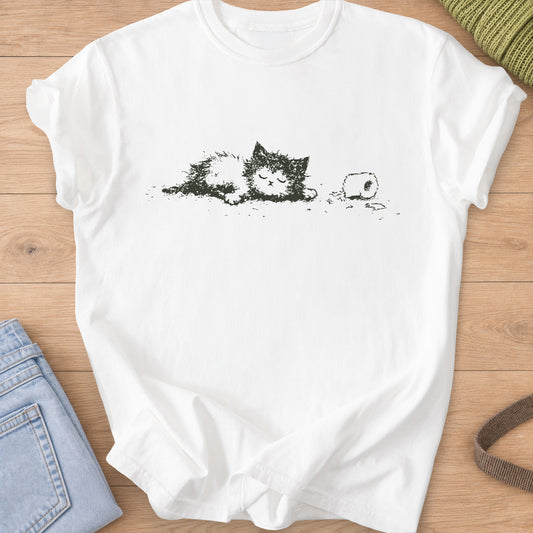 Fluffy cat napping with eyes closed beside a toilet paper roll and scattered shreds, dark charcoal ink on a White T-Shirt