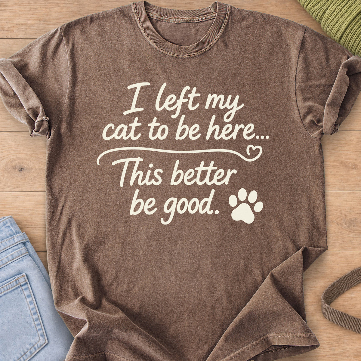 Script text "I left my cat to be here... This better be good." with a paw print, cream ink on an Espresso T-Shirt