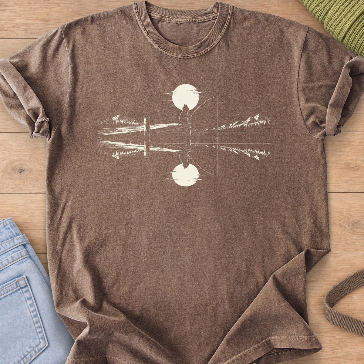 Cat silhouette fishing off a dock under a round sun, mirrored in a mountain lake, cream ink on an Espresso T-Shirt