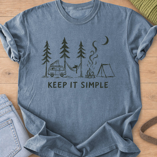 Cat in a hammock between pines with camper van, campfire, tent and "KEEP IT SIMPLE", dark charcoal ink on a Blue Jean T-Shirt