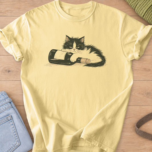 Fluffy black and white cat lying on a tipped-over wine bottle with a cork on a Butter T-Shirt