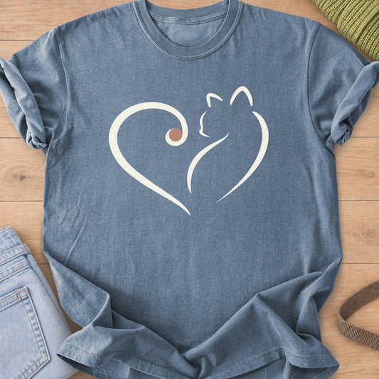 Flowing heart outline whose right side forms a sitting cat, with a small dot, cream ink on a Blue Jean T-Shirt