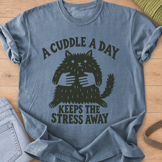 Startled fluffy cat held by two hands, "A cuddle a day keeps the stress away", dark charcoal ink on a Blue Jean T-Shirt