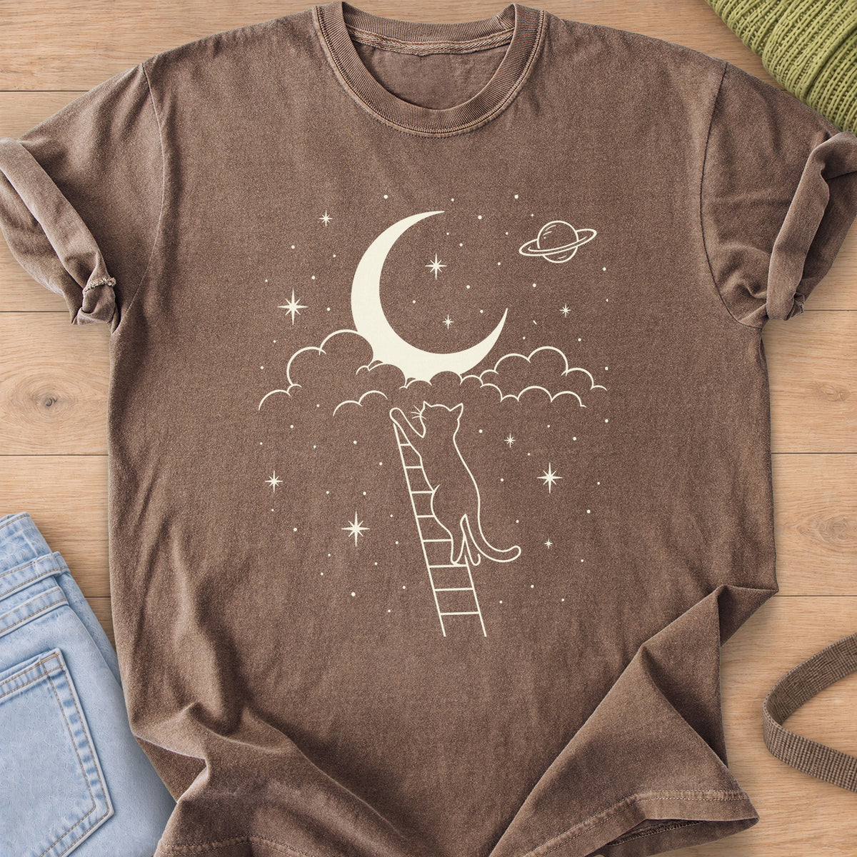 Cat on a ladder reaching up to a crescent moon in clouds, with stars and a planet, cream ink on an Espresso T-Shirt