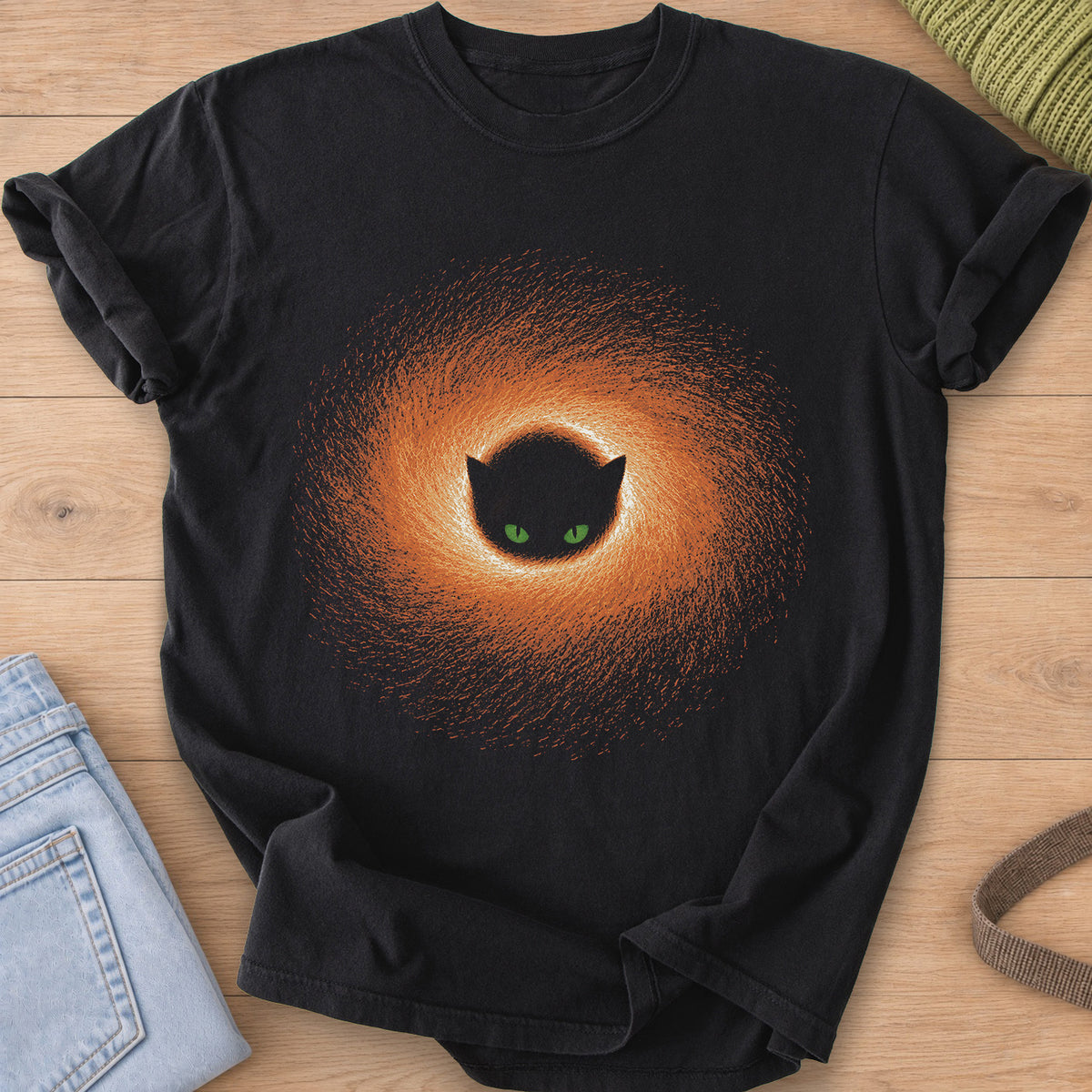 Black cat face with green eyes peering from the center of a swirling glowing portal on a Black T-Shirt