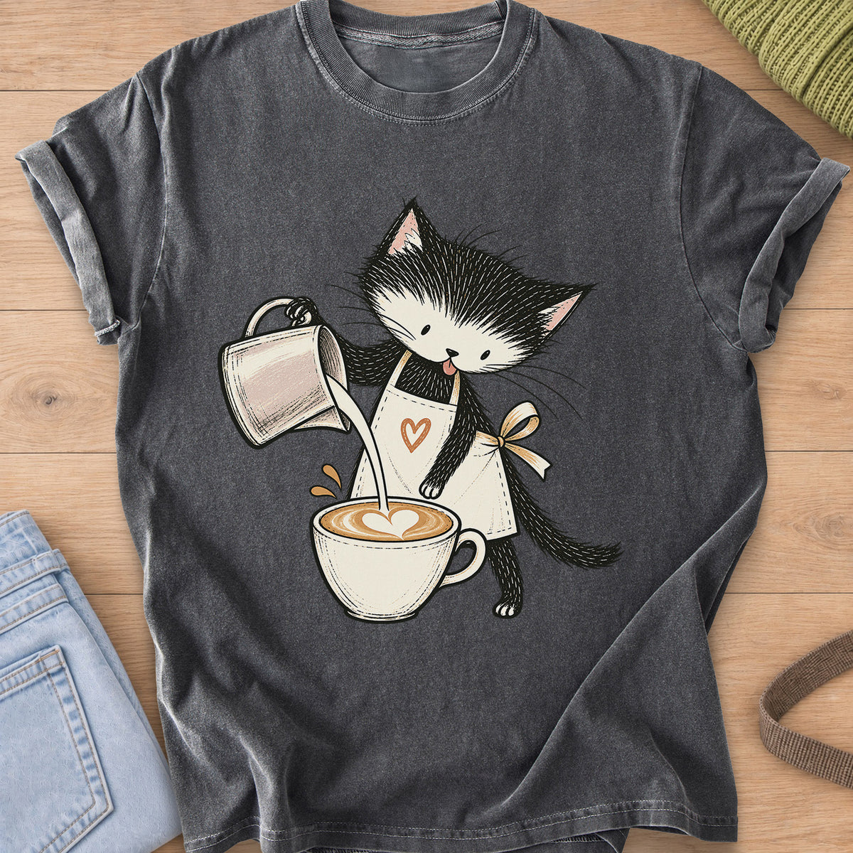 Black and white kitten in an apron pouring milk into a latte with a foam heart on a Pepper T-Shirt