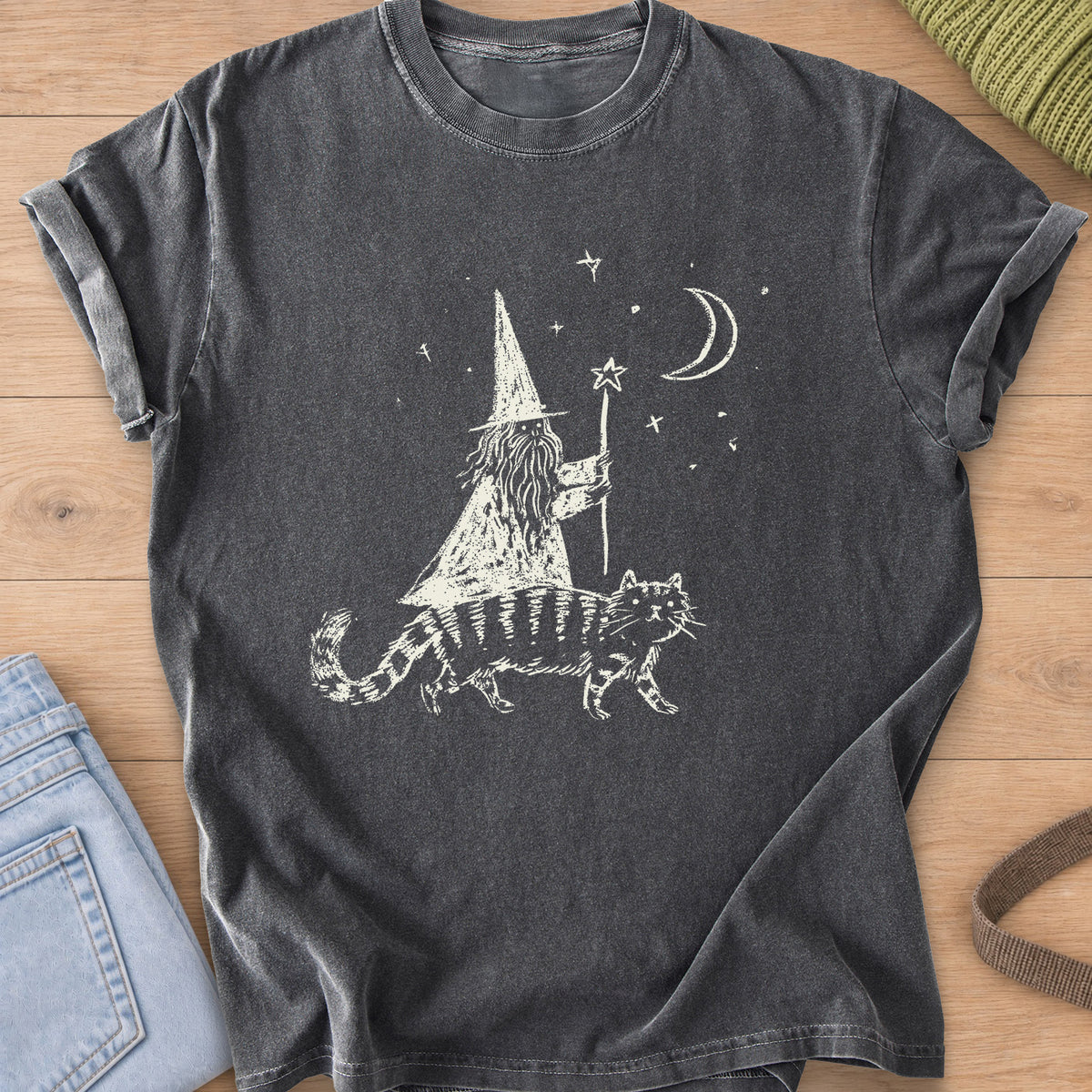 Bearded wizard with a star staff riding a striped cat under a moon and stars, cream ink on a Pepper T-Shirt