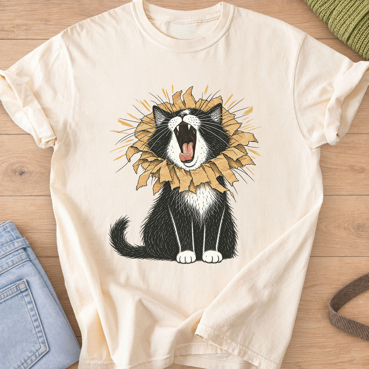 Tuxedo cat roaring with a torn paper bag mane like a lion, sunburst rays behind on an Ivory T-Shirt