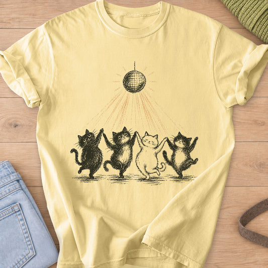 Four cats dancing paw in paw in a line under a disco ball casting light rays, black and gold ink on a Butter T-Shirt