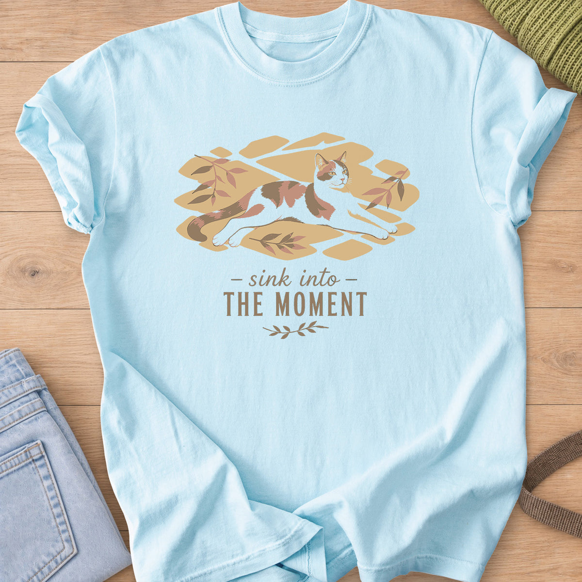 Calico cat stretched out in patches of sunlight with leaves, "sink into the moment" on a Chambray T-Shirt