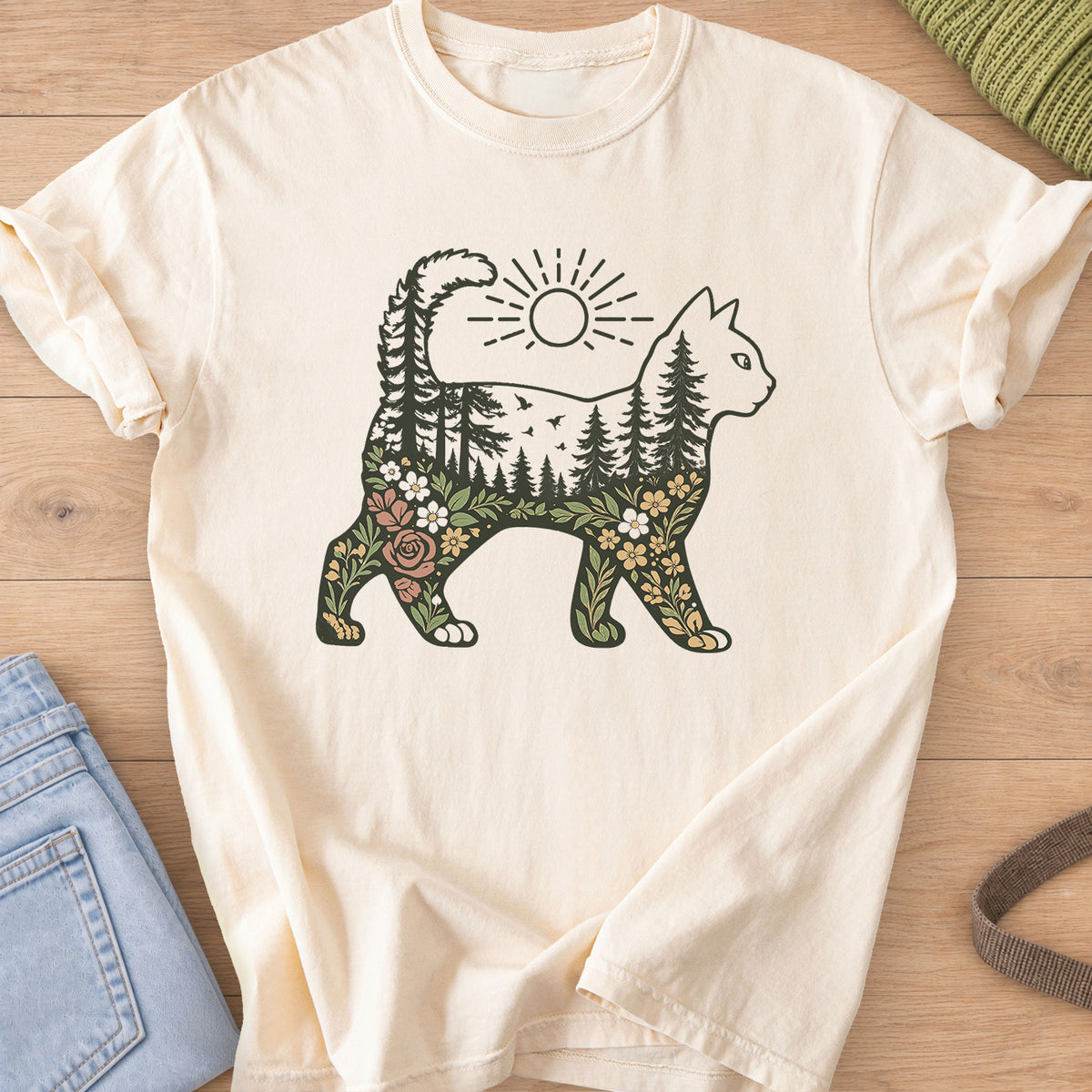 Walking cat silhouette filled with pine forest, birds, wildflowers and a sun above on an Ivory T-Shirt