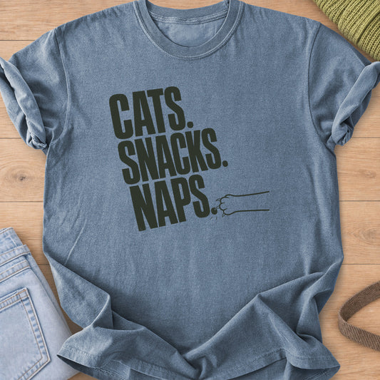 Bold "CATS. SNACKS. NAPS." lettering with a cat paw swatting the last period, dark charcoal ink on a Blue Jean T-Shirt