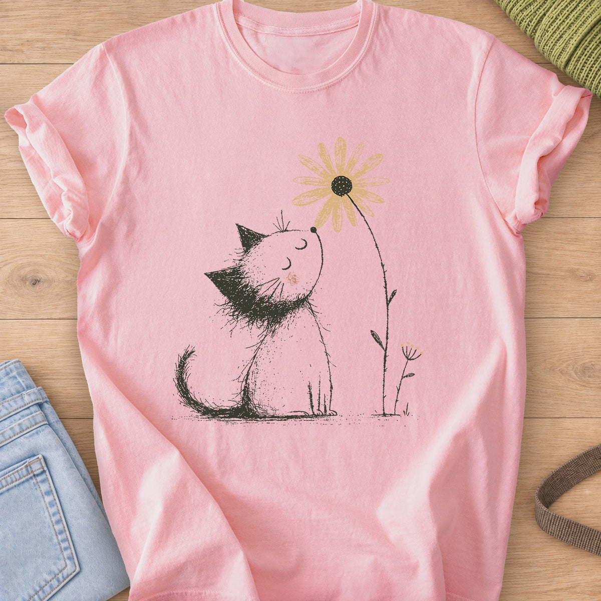 Fluffy kitten with closed eyes and a rosy cheek sniffing a tall daisy on a Blossom T-Shirt
