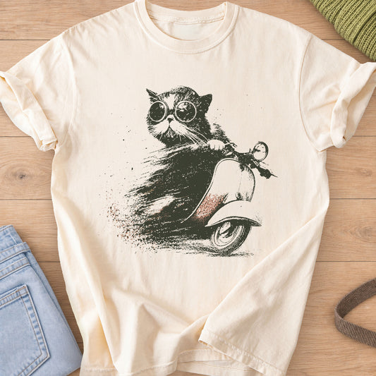 Fluffy cat in round goggles riding a vintage scooter with a dusty speed trail, dark charcoal ink on an Ivory T-Shirt