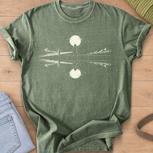 Cat silhouette fishing off a dock under a round sun, mirrored in a mountain lake, cream ink on a Moss T-Shirt
