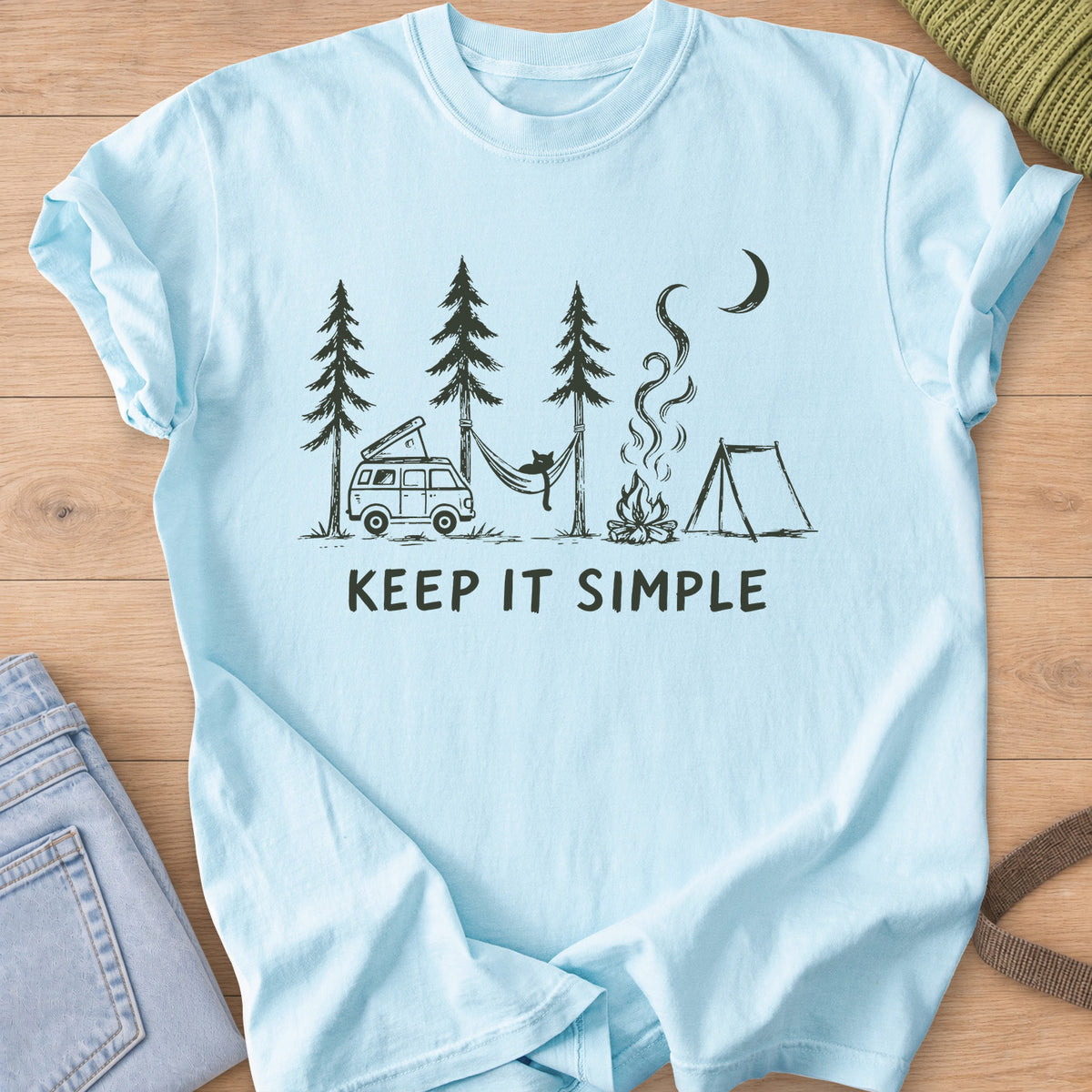 Cat in a hammock between pines with camper van, campfire, tent and "KEEP IT SIMPLE", dark charcoal ink on a Chambray T-Shirt