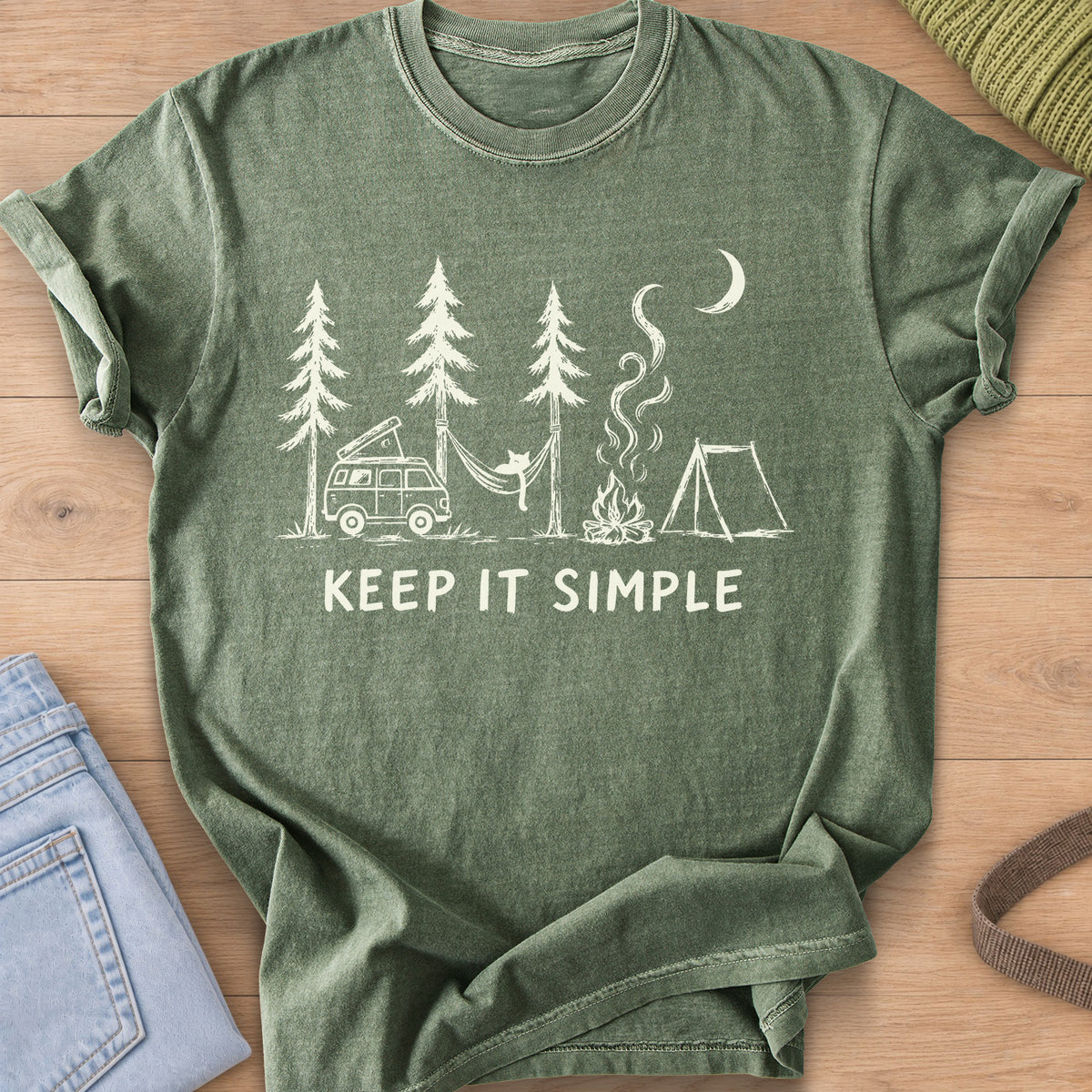 Cat in a hammock between pines with camper van, campfire, tent and "KEEP IT SIMPLE", cream ink on a Moss T-Shirt