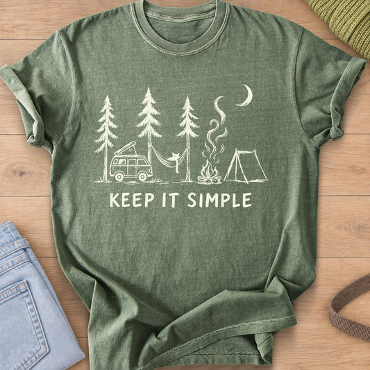 Cat in a hammock between pines with camper van, campfire, tent and "KEEP IT SIMPLE", cream ink on a Moss T-Shirt