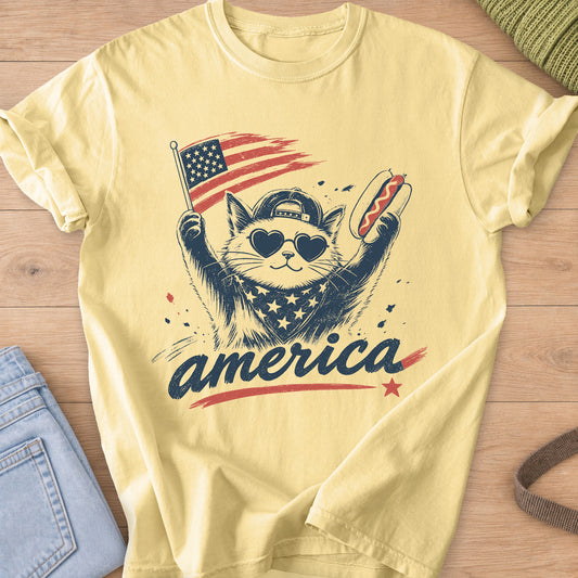 Cat in heart sunglasses and a cap holding a flag and a hot dog above "america", navy and red ink on a Butter T-Shirt