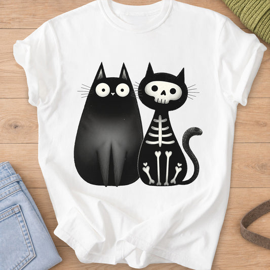 Two black cats sitting side by side, one wide-eyed and one as a skeleton, black ink on a White T-Shirt
