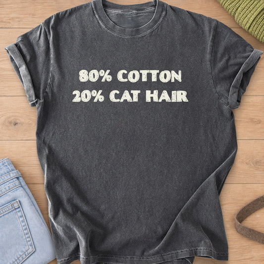 Distressed block letters that read "80% COTTON 20% CAT HAIR", cream ink on a Pepper T-Shirt