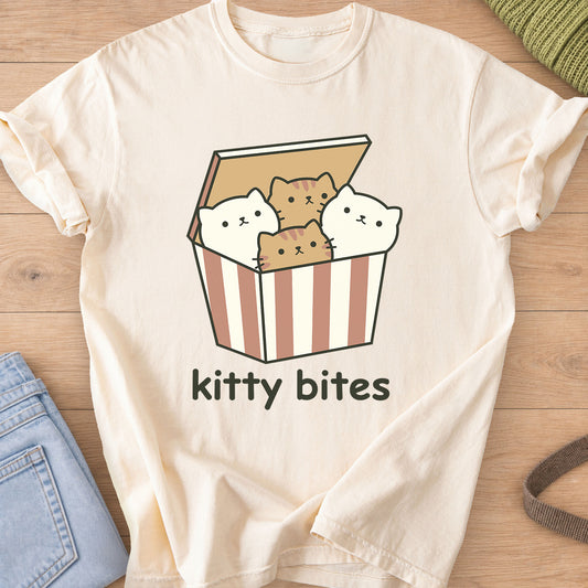 Four kittens peeking out of a striped takeout box above the words "kitty bites" on an Ivory T-Shirt