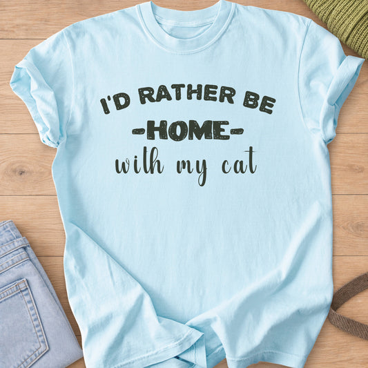 Block letters and script reading "I'D RATHER BE HOME with my cat", dark charcoal ink on a Chambray T-Shirt