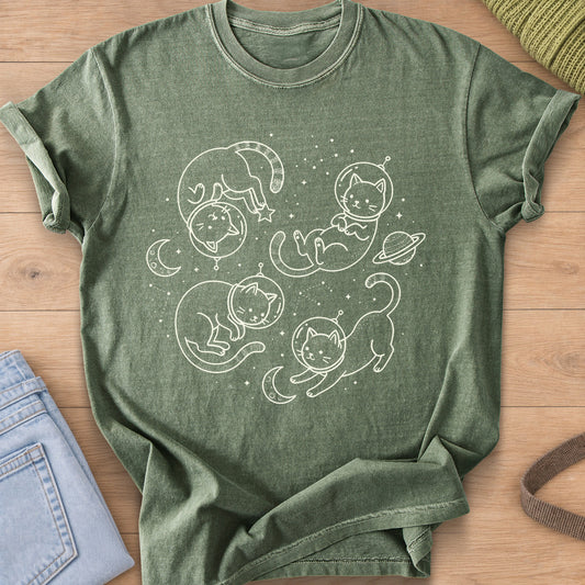 Four cats in astronaut helmets floating among stars, crescent moons and a planet, cream ink on a Moss T-Shirt