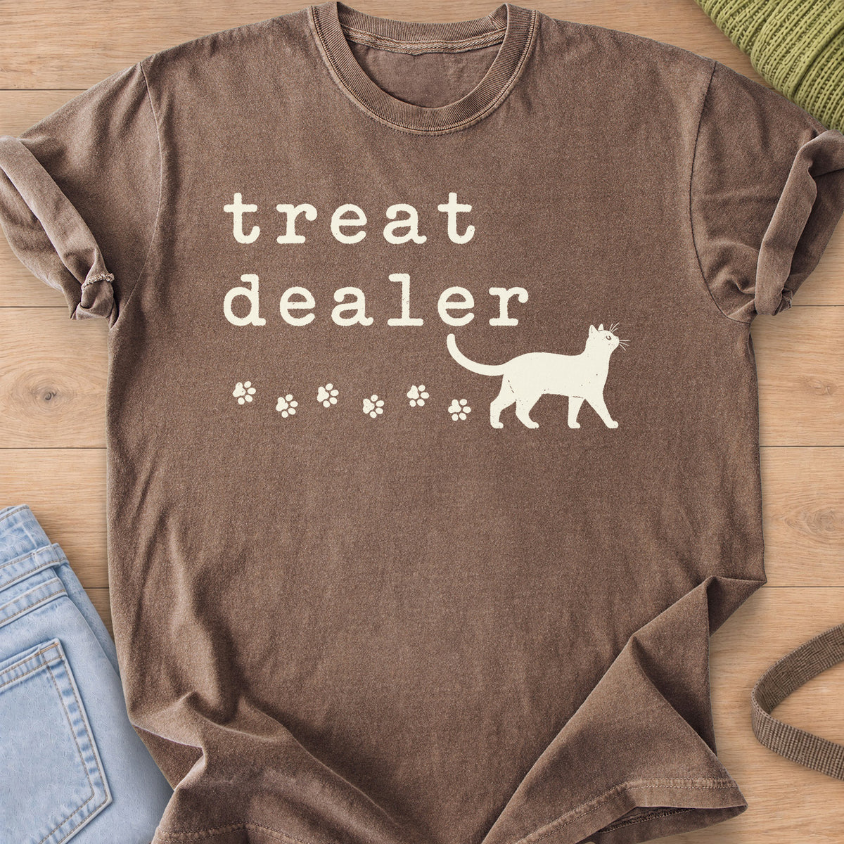 Walking cat silhouette with a trail of paw prints beneath the words "treat dealer", cream ink on an Espresso T-Shirt