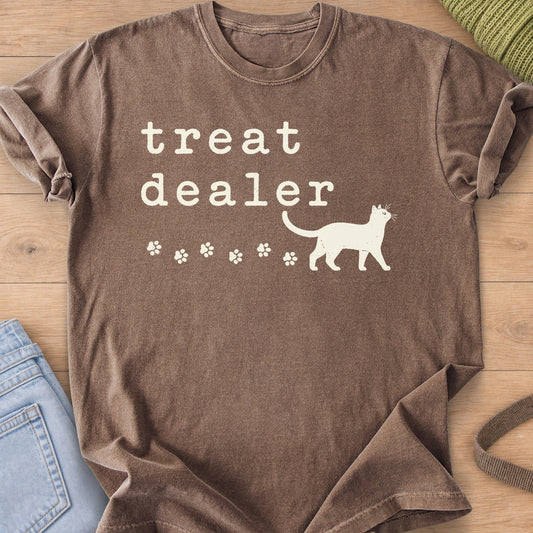 Walking cat silhouette with a trail of paw prints beneath the words "treat dealer", cream ink on an Espresso T-Shirt