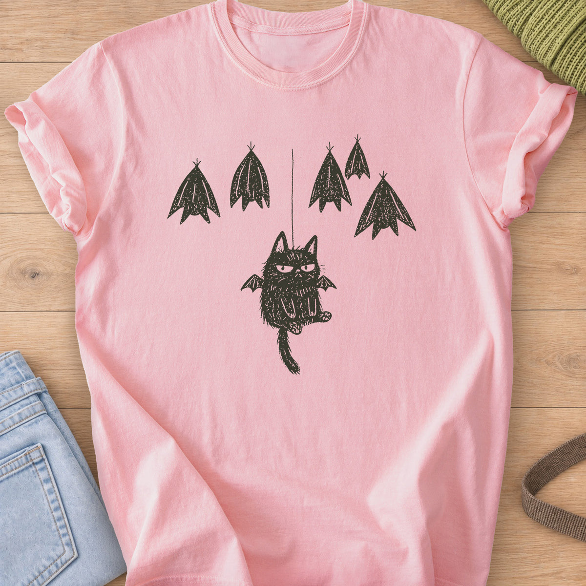 Grumpy fuzzy cat with bat wings dangling from a string among roosting bats, dark charcoal ink on a Blossom T-Shirt