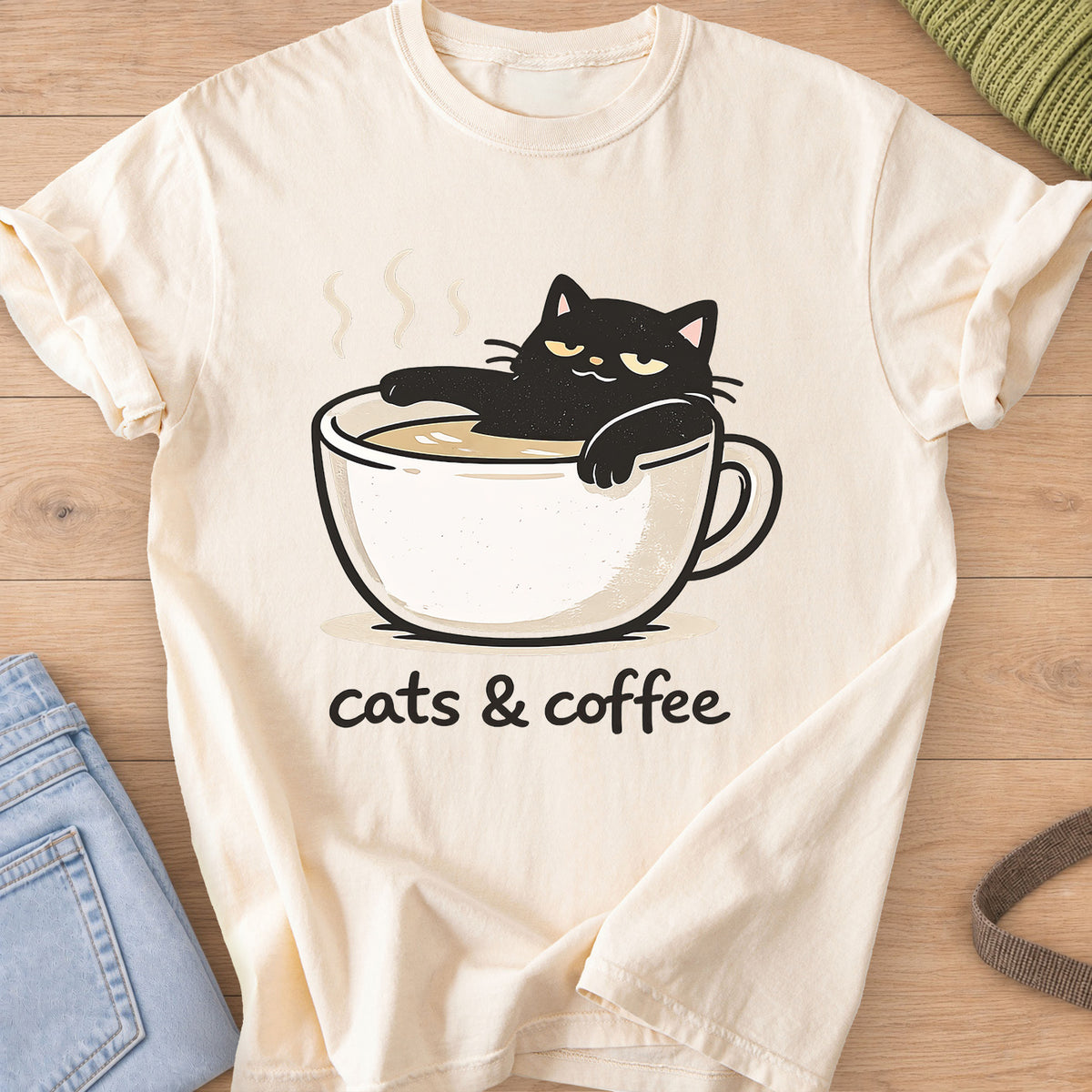 Black cat lounging in a steaming coffee cup above the words "cats & coffee" on an Ivory T-Shirt