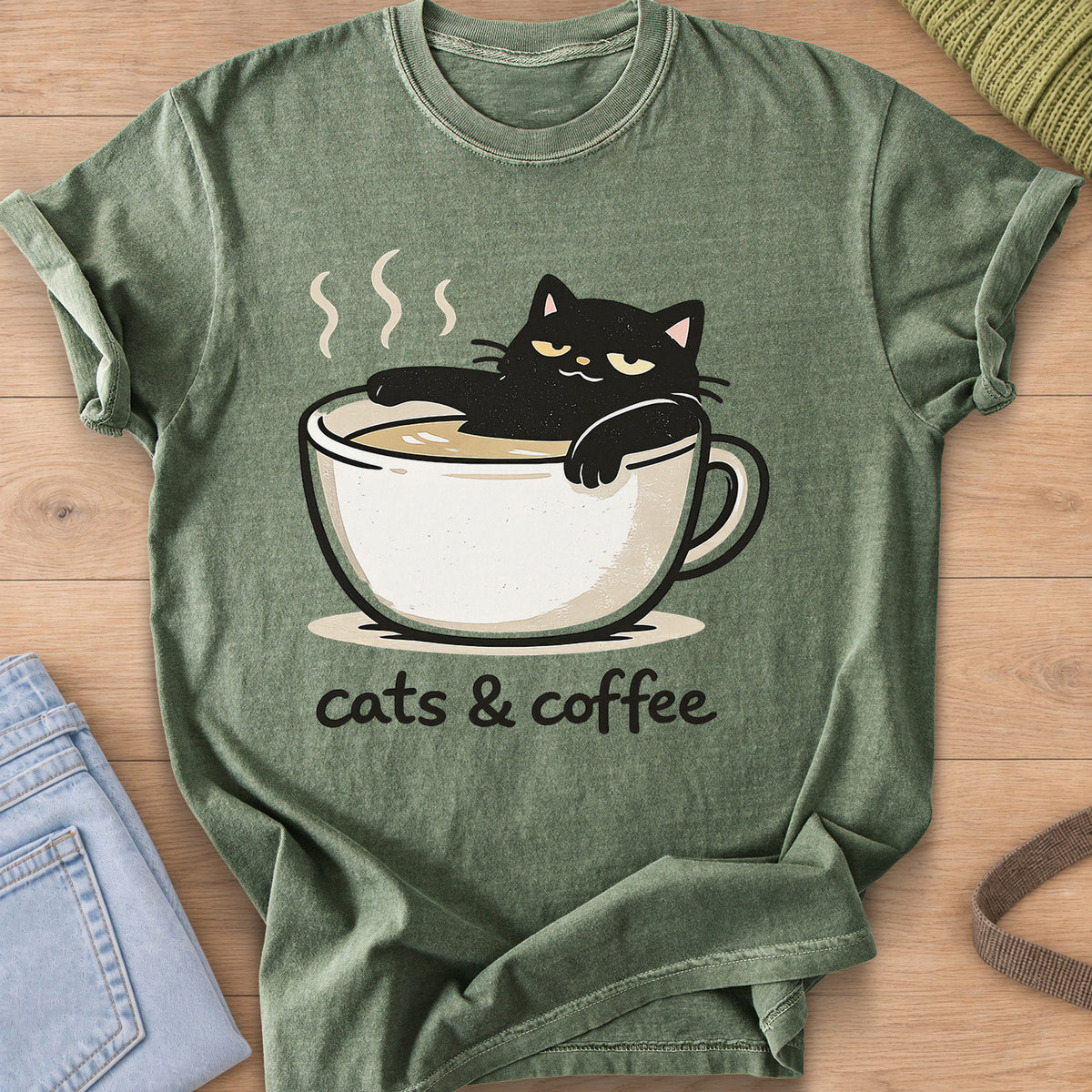 Black cat lounging in a steaming coffee cup above the words "cats & coffee" on a Moss T-Shirt