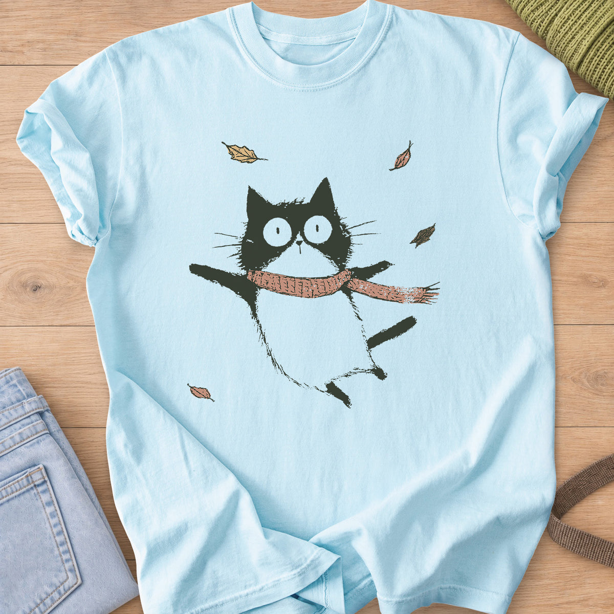 Cat in a knit scarf flying through the air, paws out, among falling autumn leaves on a Chambray T-Shirt