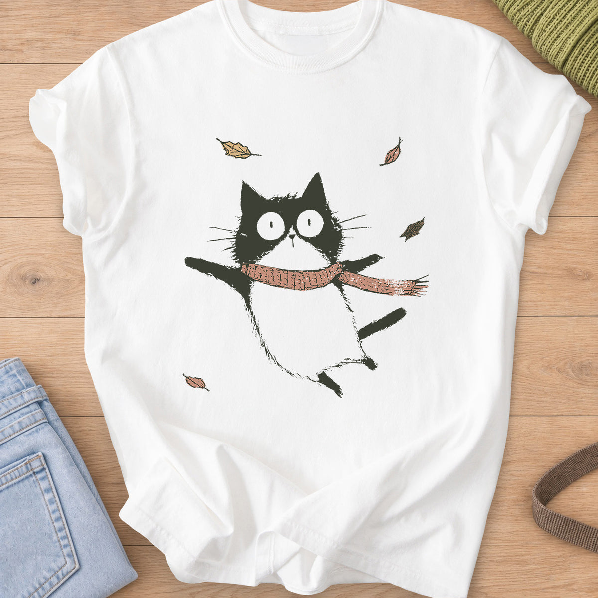 Cat in a knit scarf flying through the air, paws out, among falling autumn leaves on a White T-Shirt