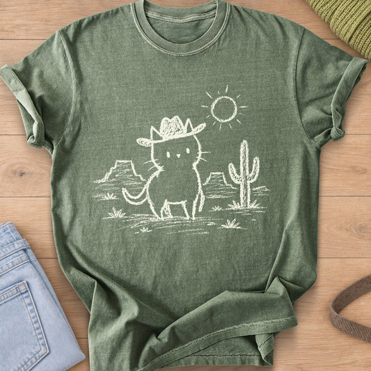 Cat in a cowboy hat standing in the desert by a cactus, mesas and a sun, cream ink on a Moss T-Shirt