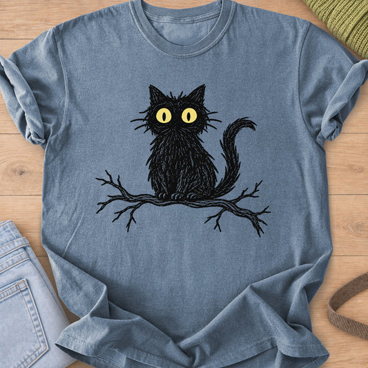 Fluffy cat with wide staring eyes sitting on a bare tree branch, black and yellow ink on a Blue Jean T-Shirt