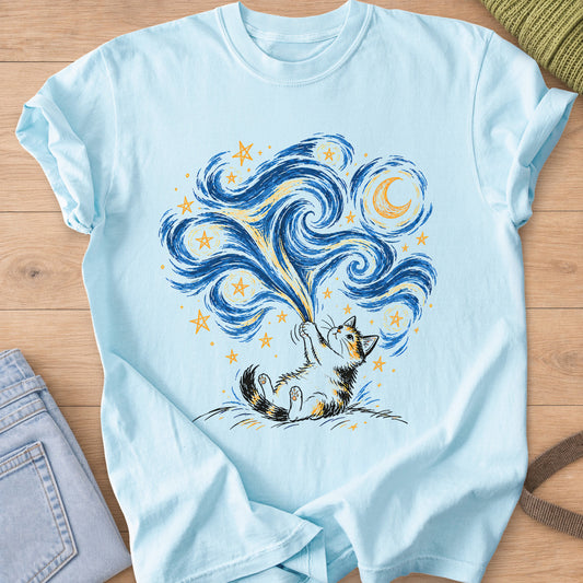 Calico cat on its back on a hill, pulling down a swirling sky of stars and a moon on a Chambray T-Shirt