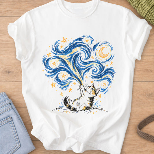 Calico cat on its back on a hill, pulling down a swirling sky of stars and a moon on a White T-Shirt