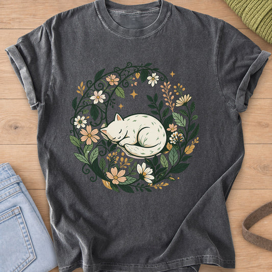 Sleeping cat curled up inside a round wreath of flowers, leaves and small stars on a Pepper T-Shirt