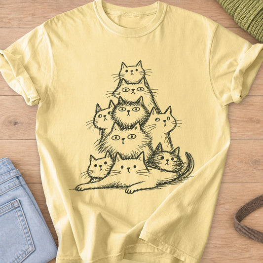 Pyramid of nine wide-eyed fluffy cats stacked up, one lying stretched at the base, dark charcoal ink on a Butter T-Shirt