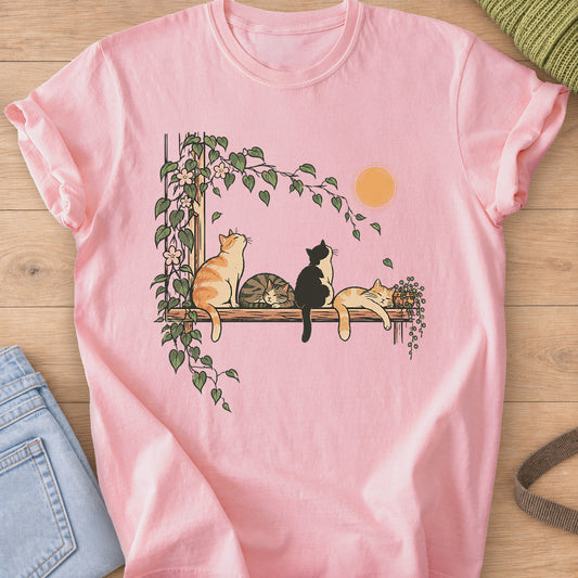 Four cats on a wooden shelf under the sun, two napping, framed by flowering vines on a Blossom T-Shirt
