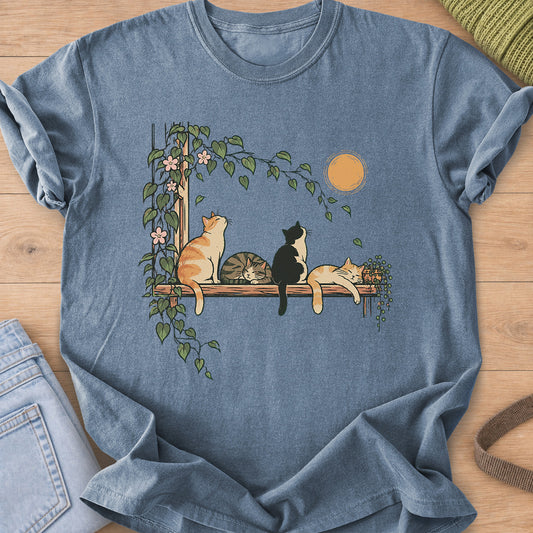 Four cats on a wooden shelf under the sun, two napping, framed by flowering vines on a Blue Jean T-Shirt