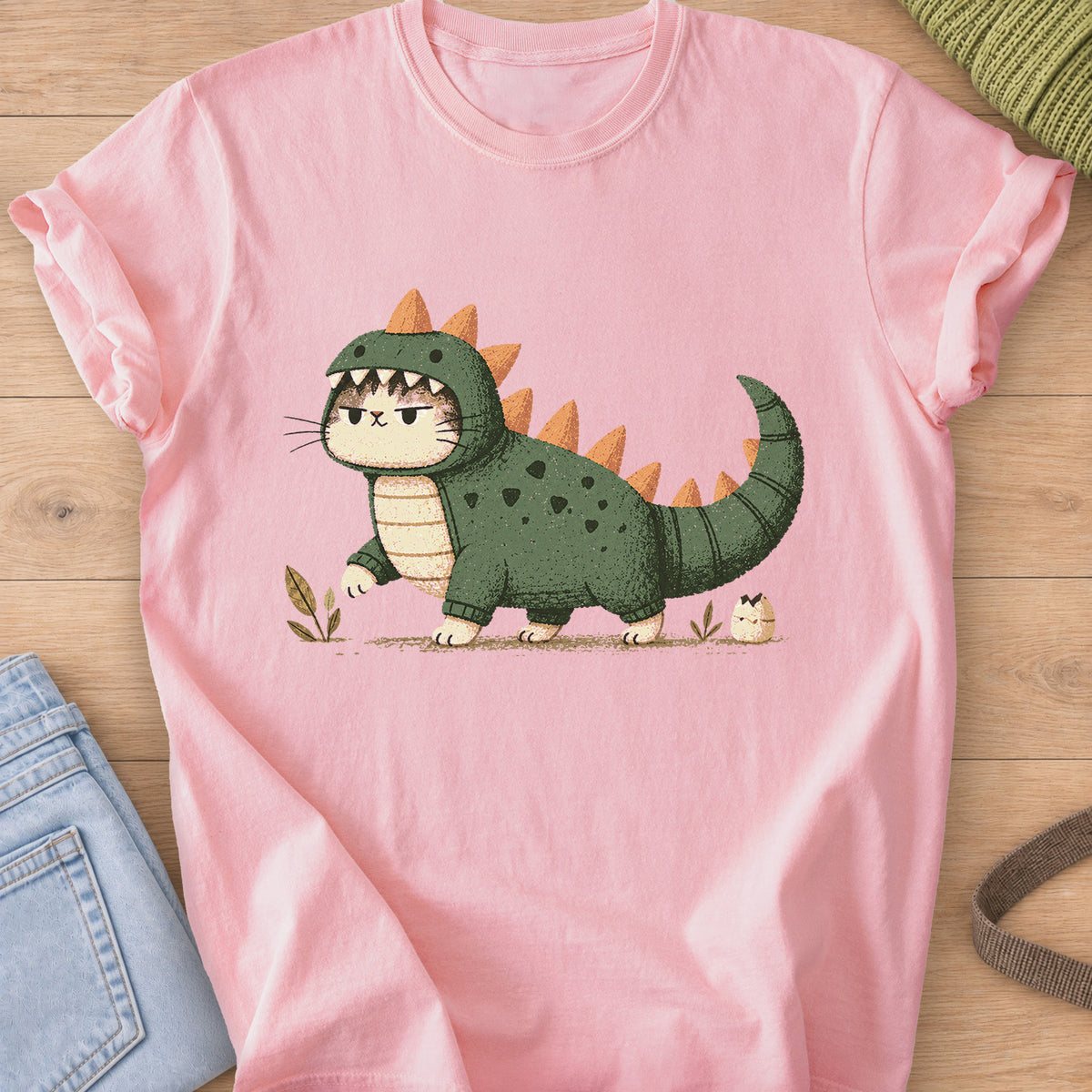 Grumpy cat in a spiky dinosaur costume walking past sprouts and a hatching egg on a Blossom T-Shirt