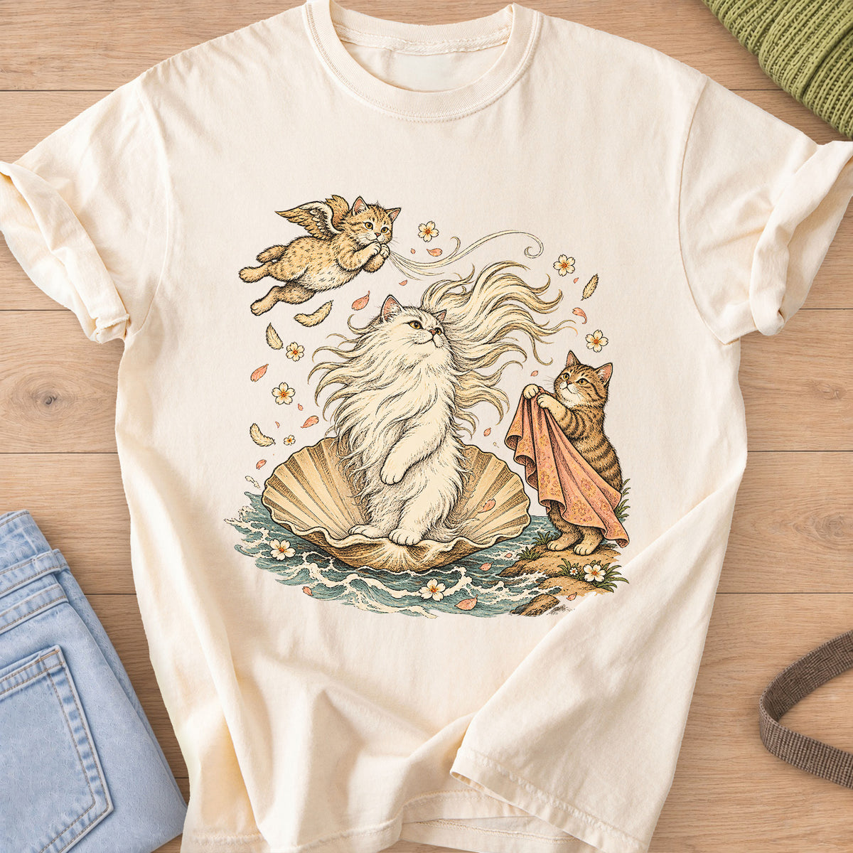 Fluffy cat on a seashell in the waves with a winged cat and a tabby holding a cloth on an Ivory T-Shirt
