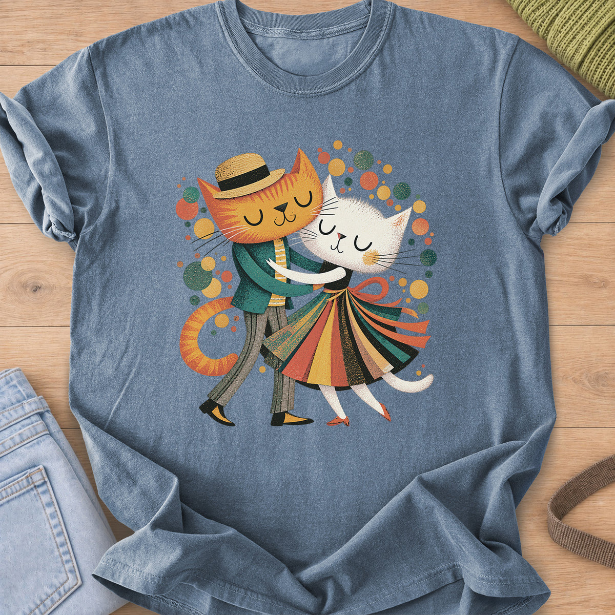 Two cats dance cheek to cheek, one in a straw hat, one in a striped skirt, amid dots on a Blue Jean T-Shirt