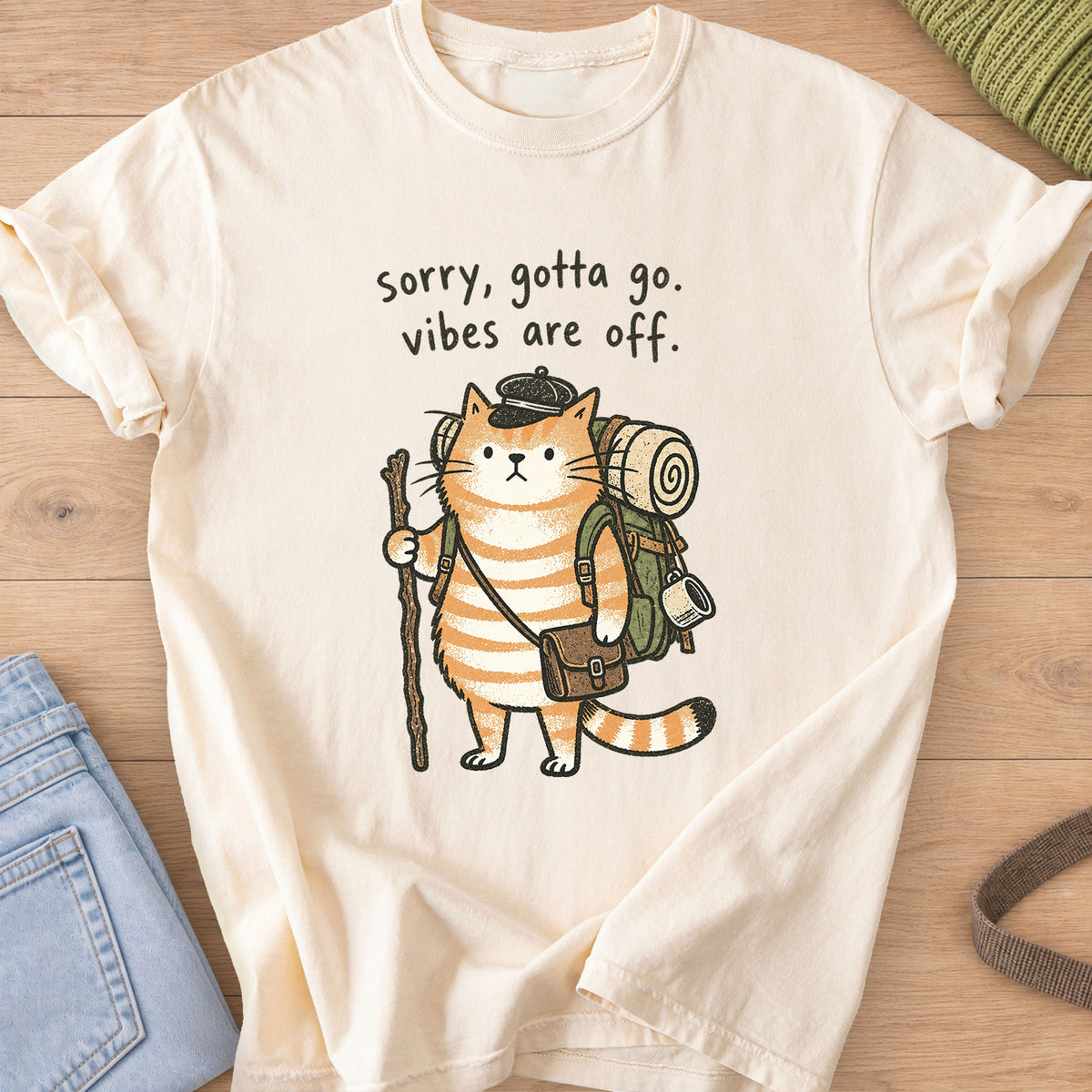 Tabby cat hiker with backpack and walking stick, "sorry, gotta go. vibes are off." on an Ivory T-Shirt