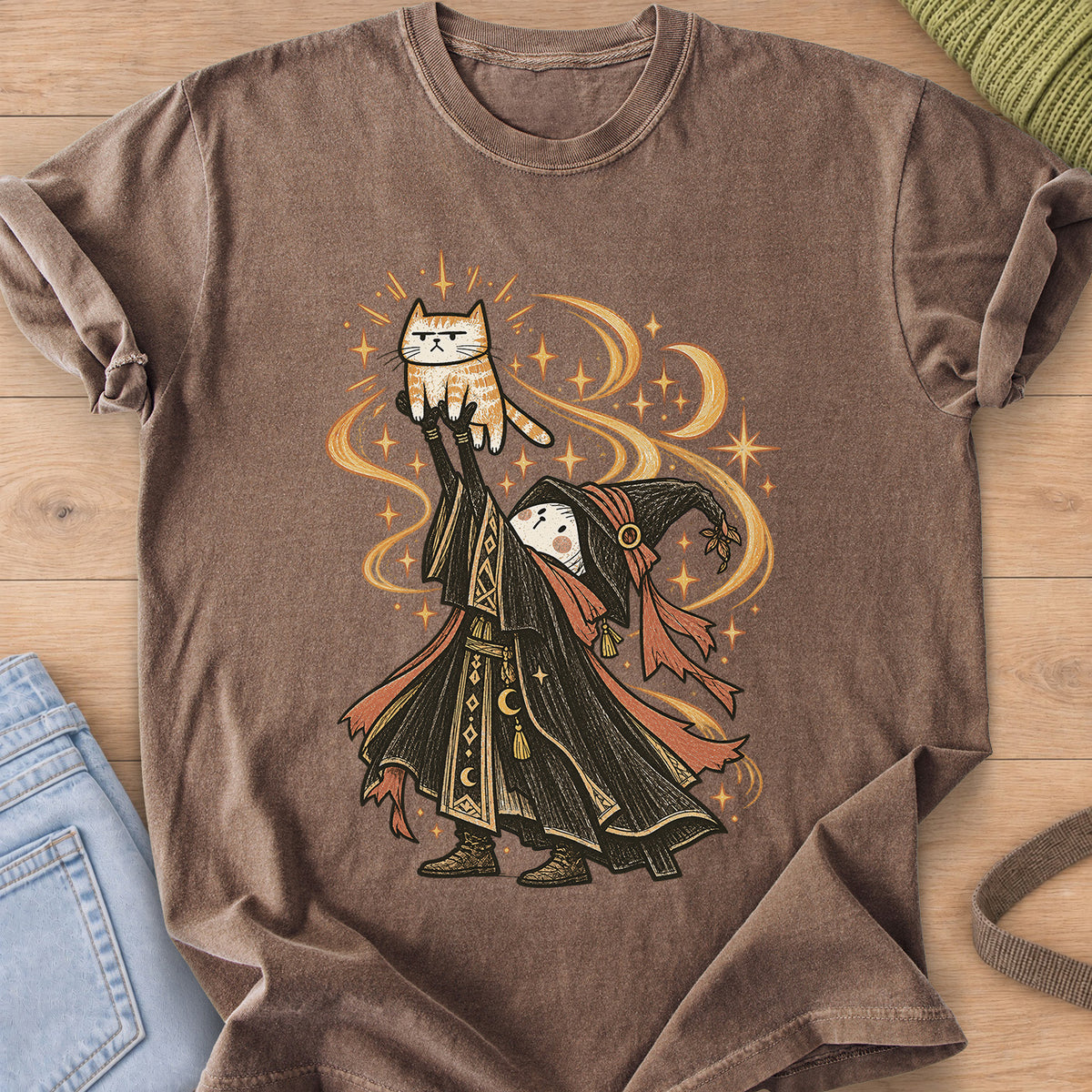 Robed wizard holds a grumpy tabby cat high overhead amid swirling stars and moons on an Espresso T-Shirt